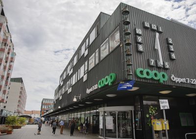 En fastighet med en coop-butik och en gågata som passerar förbi.